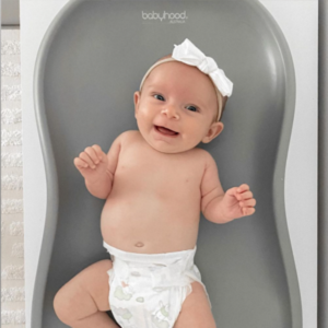 Smiling baby with white bow on gray Babyhood changing mat, Babyhood GCC product