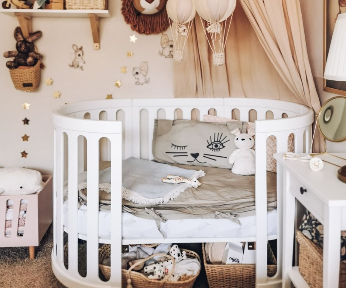 Modern baby nursery with white crib, plush toys, animal decor and cozy accessories at Babyhood GCC