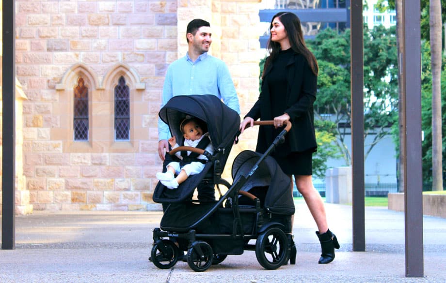Parents stroll outdoors with baby in double stroller, Babyhood GCC lifestyle scene
