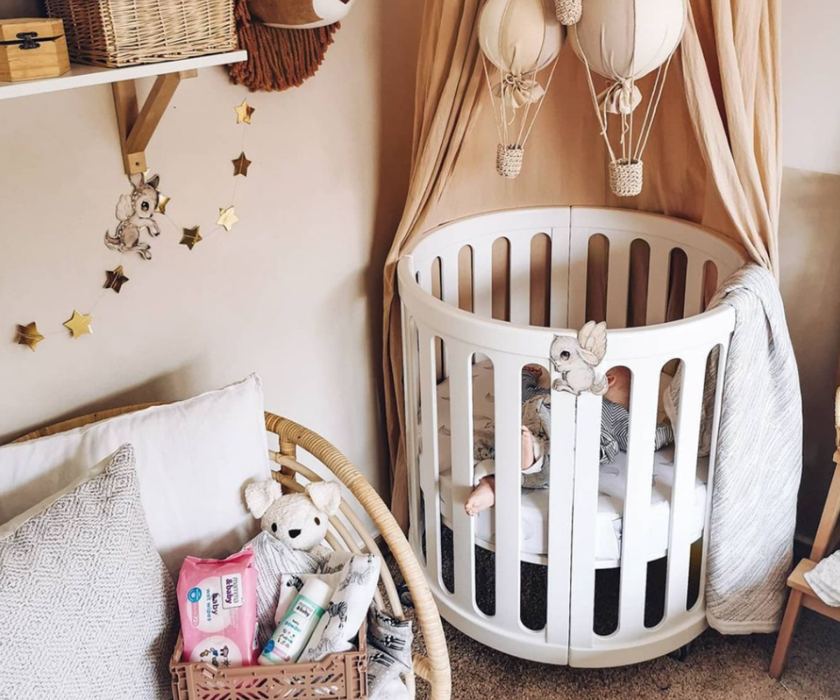 Modern baby nursery with round white crib, plush toys, and neutral decor by Babyhood GCC