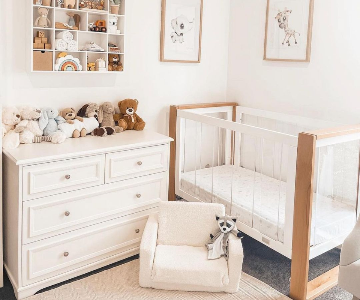 Modern baby nursery with white crib, dresser, plush toys, and animal wall art—Babyhood GCC